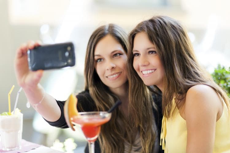 Two friends taking a selfie at a café